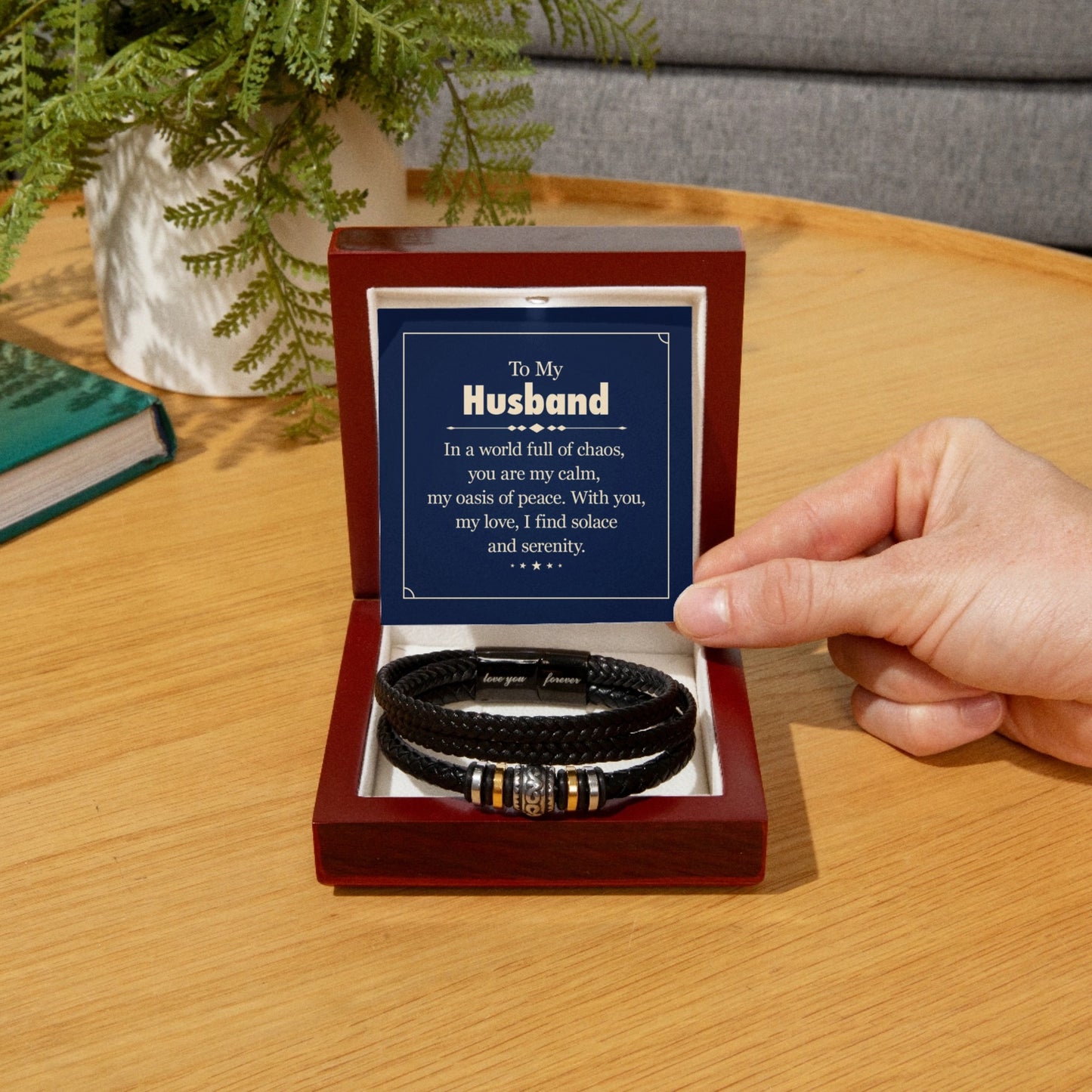 Bracelet in a wooden box with a personalized message for a husband on a wooden table.